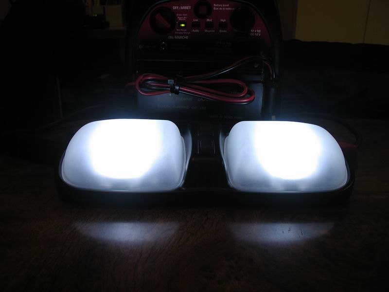Two bright white dome lights are on, with a battery charger behind them