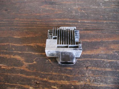 1990 Ford F-250 - Ford electronic control module with heatsink and black connector, resting on a wooden surface.