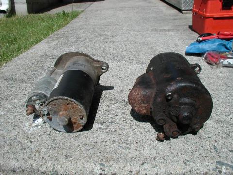 1990 Ford F-250 - Comparison of two starters, one appears newer and cleaner, the other is heavily corroded.