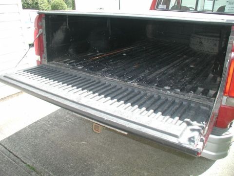 1990 Ford F-250 - The open tailgate of a 1990 Ford F-250 reveals the truck bed and a spare tire.