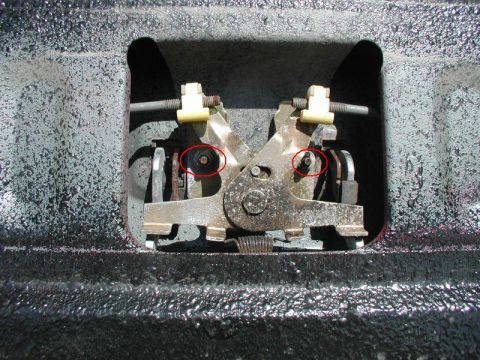 1990 Ford F-250 - Close-up of a tailgate lock mechanism, showing internal components and two highlighted screws.