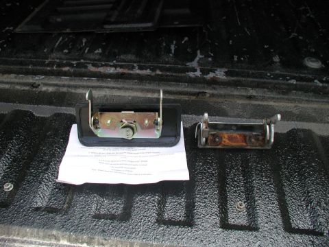 1990 Ford F-250 - Comparison of a new and a rusted tailgate lock mechanism on a truck bed liner.