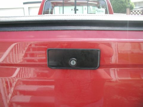 1990 Ford F-250 - Close-up of a tailgate lock assembly on a red truck.