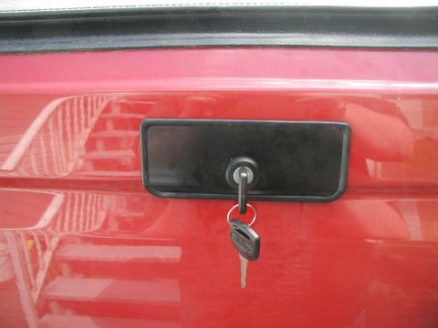 1990 Ford F-250 - A close-up of a vehicle's tailgate lock mechanism with a key inserted.