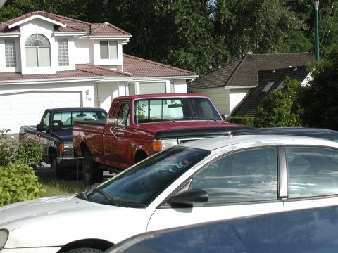 1990 Ford F-250 - A red 1990 Ford F-250 pickup truck is parked in a residential driveway.