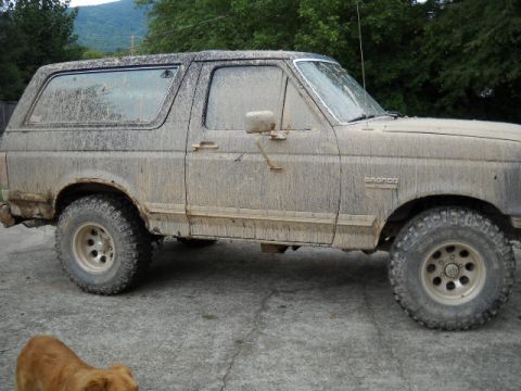 1990 Ford Bronco - This heavily soiled Ford Bronco, seen from the side, appears to be from the late 1980s, not 1990.