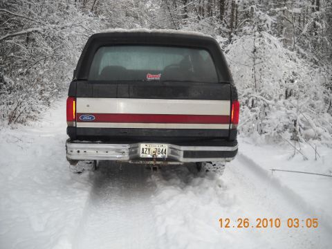 1990 Ford Bronco - Rear view of a 1990 Ford Bronco driving in the snow.