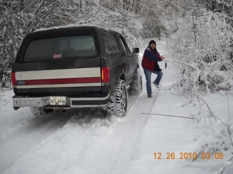 1990 Ford Bronco - A Ford Bronco navigates a snow-covered path on a winter day.