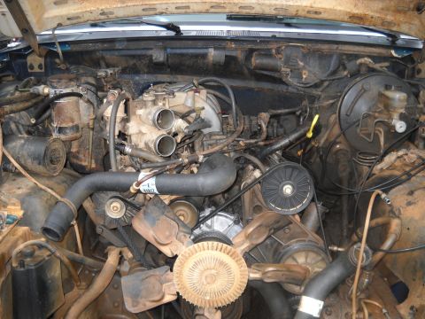 1990 Ford Bronco - Engine bay view showing V8 engine components, hoses, belts, and fan.