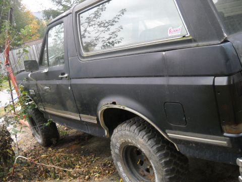 1990 Ford Bronco - This 1990 Ford Bronco is viewed from the front three-quarter angle, revealing some rust around the rear wheel well.