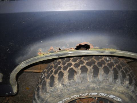 1990 Ford Bronco - Significant rust damage is visible on the wheel well of this vehicle.
