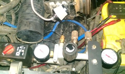 1995 Ford Bronco - Close-up of engine bay components, including air compressor parts and gauges.