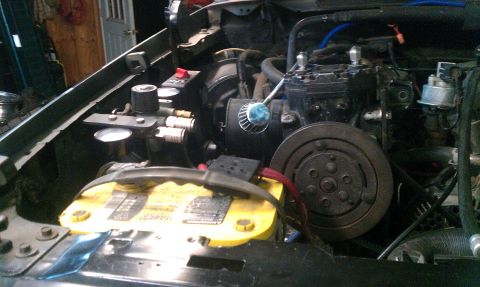 1995 Ford Bronco - Close-up view of the engine bay, focusing on the air compressor and related parts.