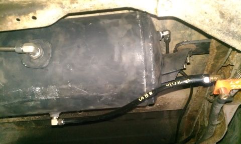 1995 Ford Bronco - Underside view of an air compressor tank with hoses and fittings.