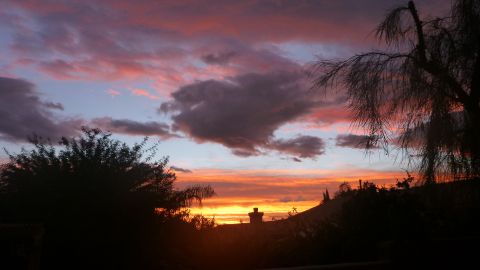 1997 Ford Ranger - Colorful sunset sky with clouds and silhouetted trees and hill. Watermark present.