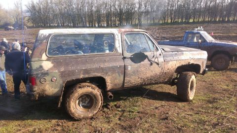 1995 Ford Bronco - This muddy SUV, likely from the 1970s, is stuck in the mud with another truck nearby.