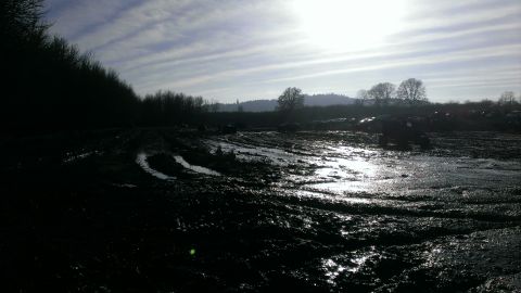 1995 Ford Bronco - Several vehicles are visible in a muddy field, with tire tracks indicating off-road activity.