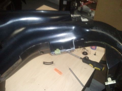 1994 Ford Bronco - A black dashboard part is shown with a screwdriver and other tools, suggesting a repair or installation process.