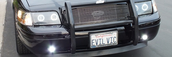 Cropped angled front of black Crown Victoria with grille guard and EVIL VIC plate