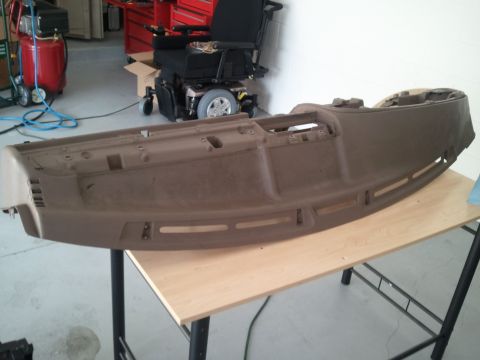 1994 Ford Bronco - A removed car dashboard is shown resting on a table in a workshop setting.