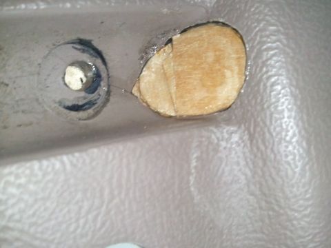 1994 Ford Bronco - Close-up of a hole cut into a vehicle's interior trim panel, with a screw nearby.