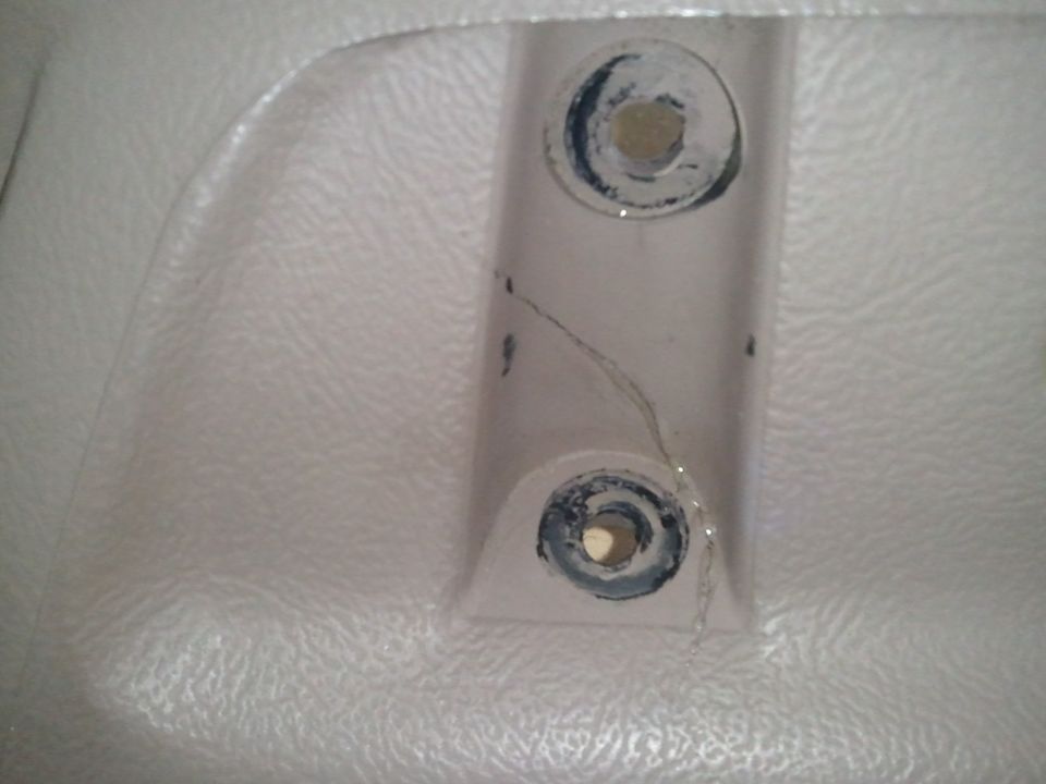 Close-up of a cracked plastic interior trim piece with two visible mounting holes