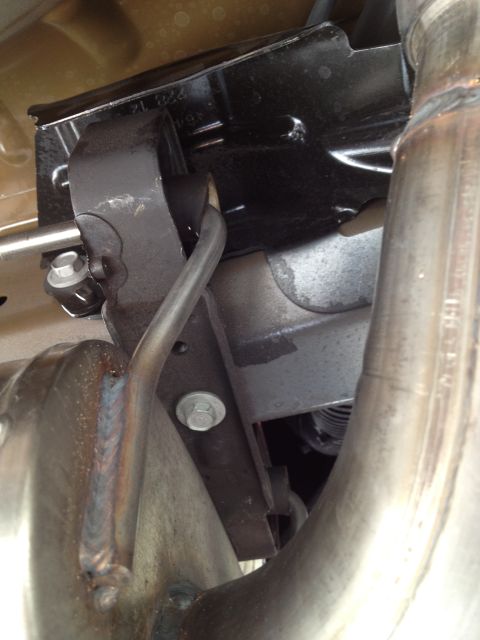2013 Ford Mustang - Close-up view of the undercarriage showing parts of the exhaust system, including pipes and mounting brackets.
