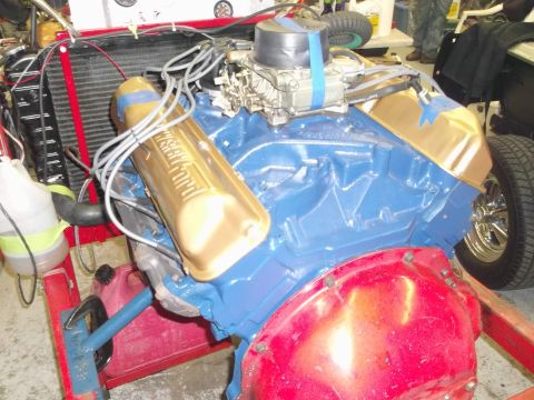 1971 Ford Ranchero - A Ford V8 engine, painted blue with gold valve covers, is mounted on a red stand.