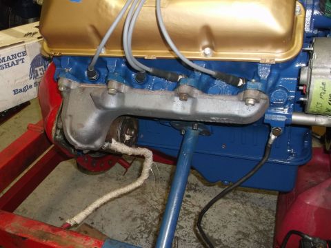 1971 Ford Ranchero - Close-up view of an engine block with gold valve covers and blue painted sections, showing the exhaust manifold.