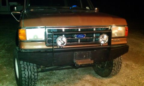 1987 Ford Bronco - Front view of a 1987 Ford Bronco a prominent push bar and fog lights.
