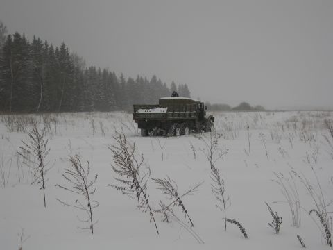 1987 Ford Bronco - A military dump truck navigates a snow-covered field during a winter day.