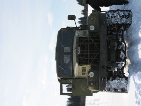 1987 Ford Bronco - This military truck is parked in the snow, with trees visible in the background.