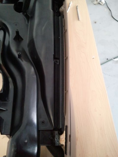 1994 Ford Bronco - Close-up of a black dashboard component, likely an air vent assembly, with visible mounting hardware.