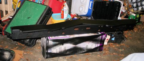 1976 Ford Ranchero - A black metal car part is shown, likely a bumper or frame component, placed on top of a box.