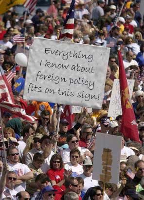 1980 Ford Bronco - Photo of a dense outdoor rally crowd waving American flags, with a hand-lettered white placard held up front reading 'Everything I know abo…
