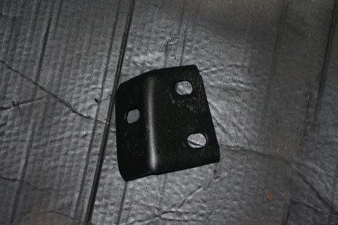 1976 Ford Ranchero - A close-up view of a black metal bracket with multiple mounting holes.