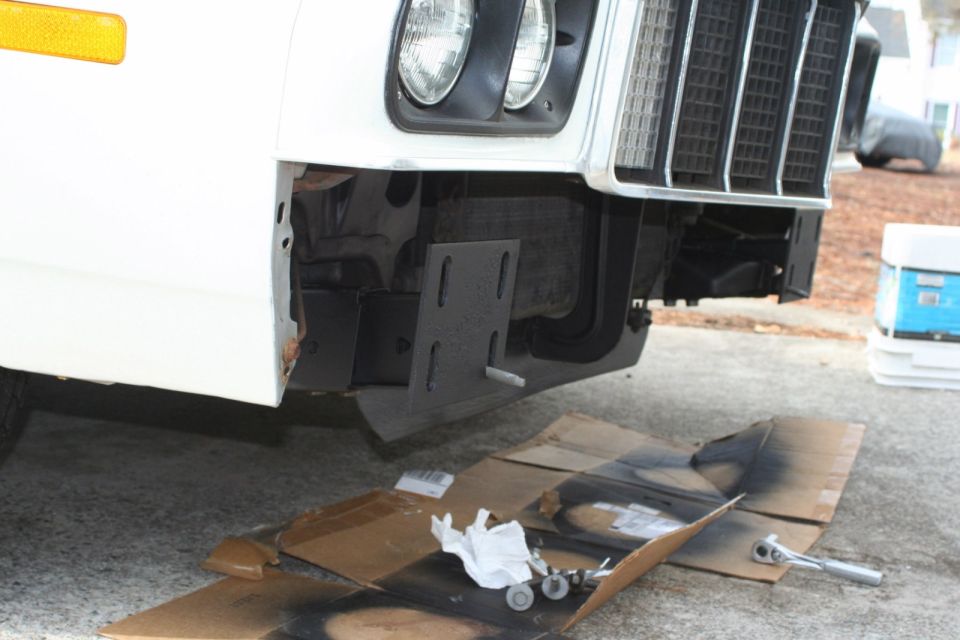 White 1976 Ford Ranchero front bumper area with custom bracket installed
