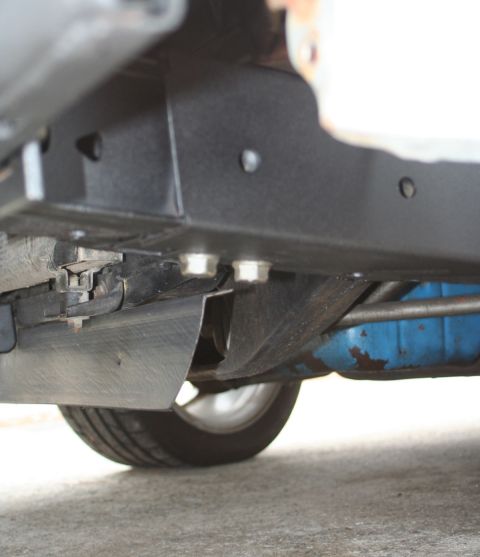 1976 Ford Ranchero - A low-angle view of a vehicle's undercarriage reveals its frame, suspension, and a tire.
