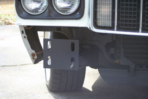 1976 Ford Ranchero - Front view of a white 1976 Ford Ranchero showing a black mounting bracket attached to the bumper.