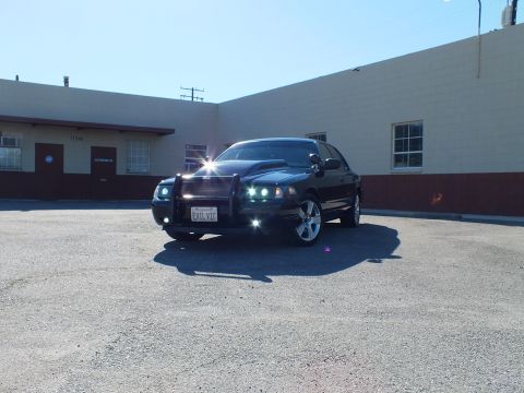 2003 Ford Crown Victoria - Front view of a modified 2003 Ford Crown Victoria parked outside a commercial building.