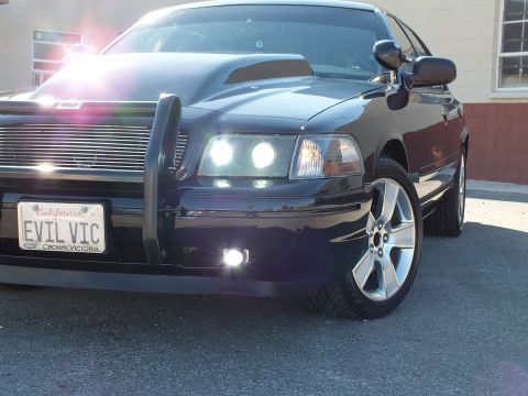 2003 Ford Crown Victoria - Detail of a Crown Victoria's billet grille, fog light and Ford-framed EVIL VIC plate with chrome wheel.