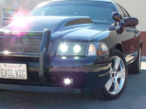 2003 Ford Crown Victoria - Tight angle on a custom Crown Victoria showing billet grille, brush guard and aftermarket alloy wheel.