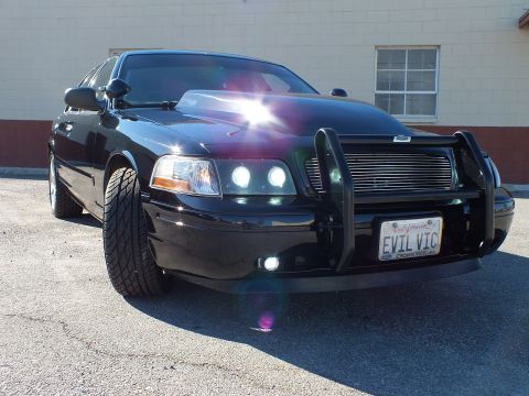 2003 Ford Crown Victoria - Close front-corner view of a modified Crown Victoria with billet grille and chrome alloy wheel.