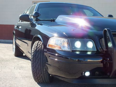2003 Ford Crown Victoria - Detail shot of a custom Crown Victoria front, halo projector lamp, side mirror and aftermarket wheel.