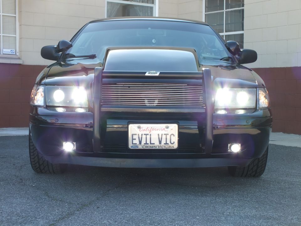 Black Crown Victoria head-on view with cowl hood, grille guard and EVIL VIC California plate