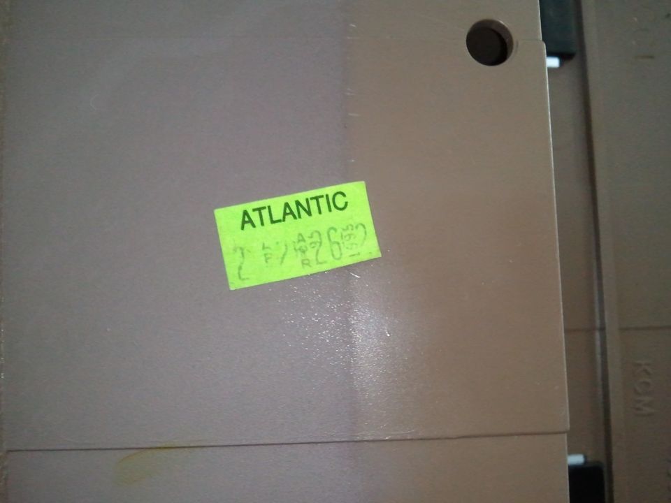 Tan dashboard part with green "ATLANTIC" sticker and handwritten numbers