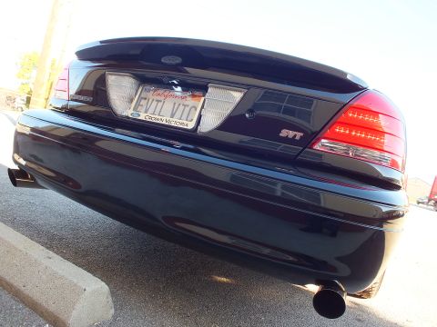 2003 Ford Crown Victoria - Symmetrical low rear view of a black sedan, SVT badging, EVIL VIC plate and twin exhaust outlets.