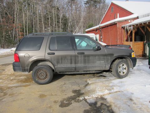 1991 Ford Crown Victoria LTD - A dirty Ford Explorer is parked outside a red barn with icicles hanging from the roof.