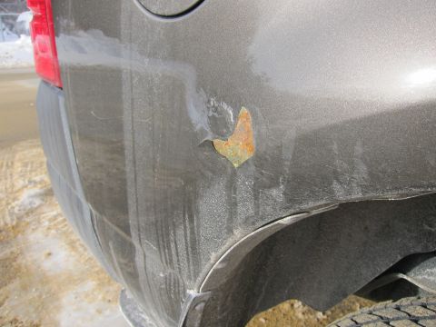 1991 Ford Crown Victoria LTD - The rear quarter panel of a vehicle shows significant rust damage, indicating potential corrosion issues.