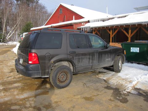 1991 Ford Crown Victoria LTD - A Ford Explorer SUV is parked in front of a red barn during winter with icicles hanging from the roof.